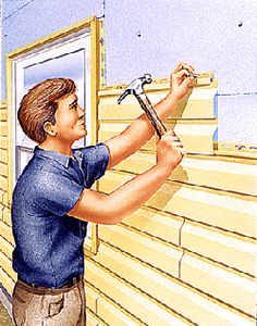 a man holding a wrench on the side of a building with siding being installed