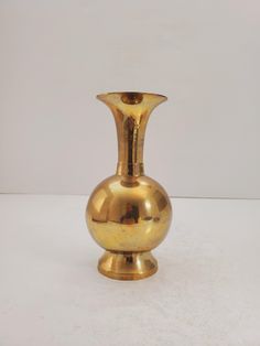 a golden vase sitting on top of a white table