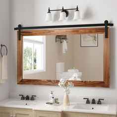 a bathroom with two sinks and a large mirror over the sink in front of it