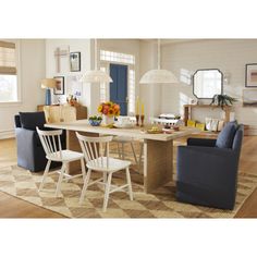 a dining room table with chairs and a rug on the floor in front of it