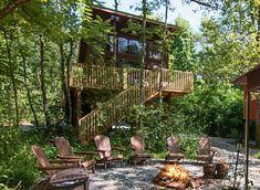 an outdoor fire pit with chairs around it and stairs leading up to the top floor