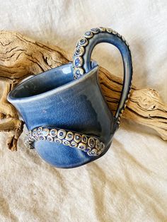 an octopus mug is sitting on a bed