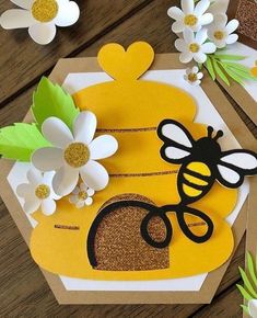 a card with flowers and a bee on it sitting on a table next to other cards