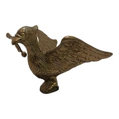 a metal bird figurine on a white background