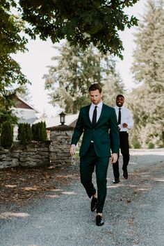 two men in suits are walking down the street