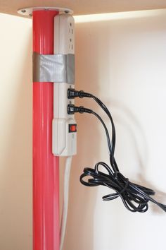 a red and white pole with two wires attached to the wall next to an electrical outlet