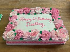 a birthday cake with pink frosting roses on it