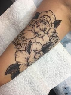 a black and white flower tattoo on the arm