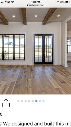 an empty room with wood flooring and black glass doors on the front door is seen in this instagram