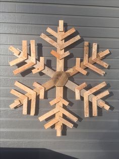 a wooden snowflake hanging on the side of a building