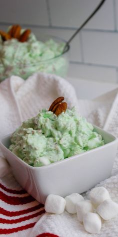 a bowl filled with food sitting on top of a white towel next to marshmallows