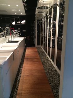 a long narrow hallway with sinks and mirrors