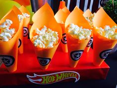 orange cones filled with popcorn sitting on top of a table