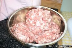 a metal bowl filled with meat sitting on top of a counter