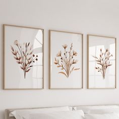 three framed pictures hanging on the wall above a bed in a room with white sheets and pillows