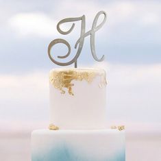 a white and blue cake with the letter ef on top