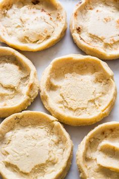 several small pies sitting on top of a white plate with one missing the crust