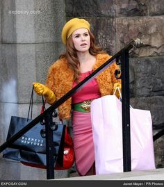 a woman carrying shopping bags down the stairs with her handbag in her other hand