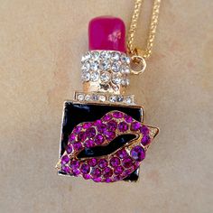 This Unique And Quirky Necklace Features A Deep Pink Lipstick Charm. A Pair Of Rhinestone Studded Lips Decorate The Front Of This Cosmetic Pendant. This Pendant Measures About 2" In Height And About 1.75" Across. It Hangs At An Angle From A 23" Gold Colored Chain And Comes With A 2.5" Extension. Has A Nice Weight To It. Brand New & In Excellent Condition. Perfect For Any Mua Or Beauty Queen! :) Glamorous Pink Rhinestone Necklace For Party, Pink Bling Necklace For Gift, Pink Rhinestone Bling Necklace Gift, Pink Rhinestone Bling Necklace For Gift, Pink Rhinestone Necklace With Bling For Gift, Purple Rhinestone Necklace For Gift, Glamorous Pink Rhinestone Necklace, Deep Pink Lipstick, Quirky Necklace