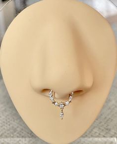 a mannequin's head with a diamond necklace on it and a ring in the shape of a nose