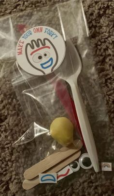 a toothbrush and wooden spoon in plastic packaging on the floor with stickers around it