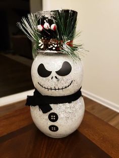 a snowman with a top hat and black bow tie sitting on a wooden table