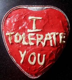 a heart shaped cake with the words i tolerate you written on it