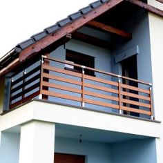 a white and blue house with a wooden balcony