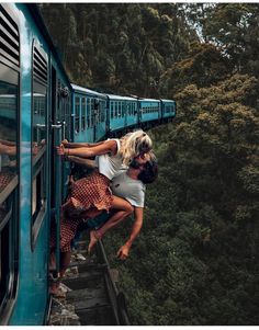 two people climbing up the side of a train