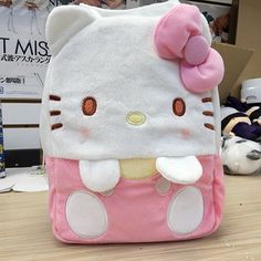 a hello kitty backpack sitting on top of a wooden table