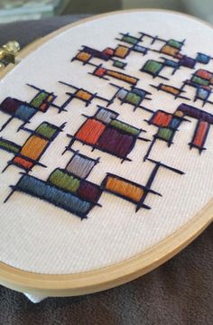 a close up of a cross stitch on a table