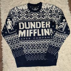 a sweater with the words dunder miffinn on it sitting on a white carpet