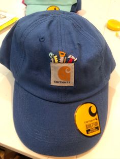 a blue hat sitting on top of a table next to a pair of scissors and pencils