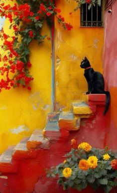 a black cat sitting on top of a red and yellow wall next to some flowers