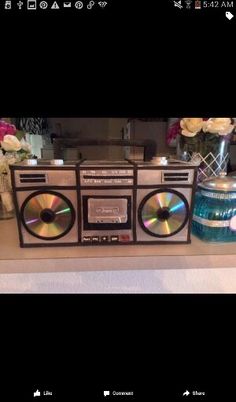 an old fashioned radio sitting on top of a counter next to vases with flowers