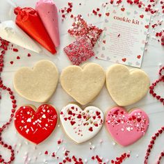 heart shaped cookies on a table with confetti