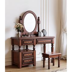 a wooden dressing table with mirror and stool