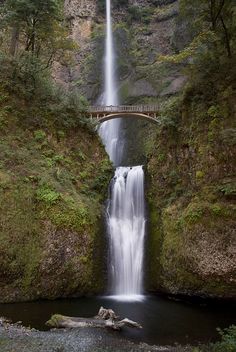 a large waterfall with a bridge over it