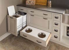 an open drawer in the kitchen with two bowls and one bowl on it's side