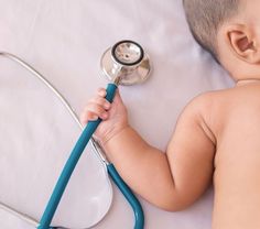 a baby with a stethoscope laying on top of it's back