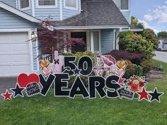 a sign that says 50 years in front of a house with hearts and stars on it