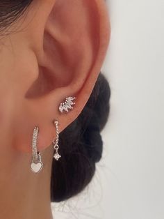 Stunning silver dainty earring set.Create your unique ear stack by choosing individual pairs or collecting them all! HypoallergenicNickel Free and Lead FreeSold as a pairA. White heart dangle• Material: White gold Plated on 925 Sterling Silver, Cubic Zirconia• Size: 18mm in length , Hoop inner diameter : 10mm B. Dainty CZ Dangle• Material: White gold Plated on 925 Sterling Silver, Cubic Zirconia• Size: 16mm in length, Hoop inner diameter : 8mm C. Swan Stud• Material: White gold Plated on 925 Ste Earrings White Gold, Set Earrings, Ear Piercing Silver, Silver Dainty Earrings, Piercings Ear Silver, Silver Earring Set, Earring Stack Silver, Silver Stacked Earrings, Earring Set Ideas