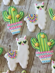 decorated llamas and cactus cookies on a wooden table