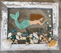 a little mermaid is sitting on the beach with shells and pearls in front of it