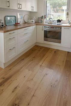 a kitchen with wooden floors and white cabinets