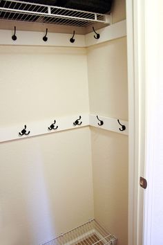 an empty closet with several hooks on the wall