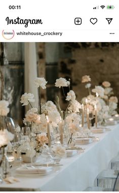 a long table is set with white flowers and candles for a formal dinner or reception