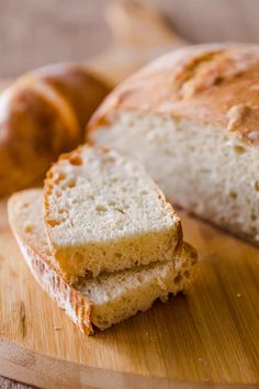 two loaves of bread sitting on top of a wooden cutting board