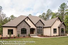 a large house with stone and brick accents in the front yard, surrounded by trees