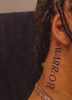 a man with dreadlocks has a tattoo on his neck that reads warrior or